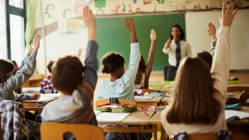 Children in Classroom Raising Hands Slightly Different Crop