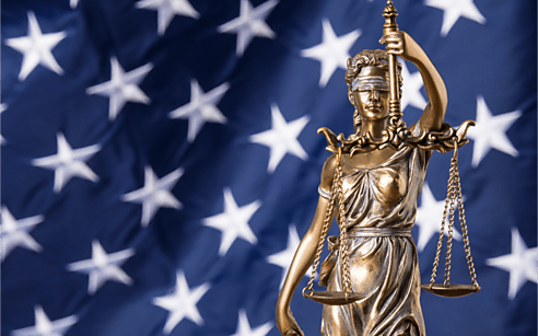 Lady justice holding scales against an American flag background