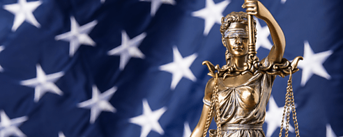 Lady justice holding scales against an American flag background