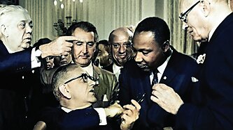 Martin Luther King, Jr. participates in the signing of the Civil Rights Act.