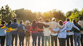 A group of people stand with arms around each other