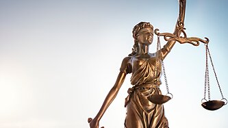 Lady justice against a pale background